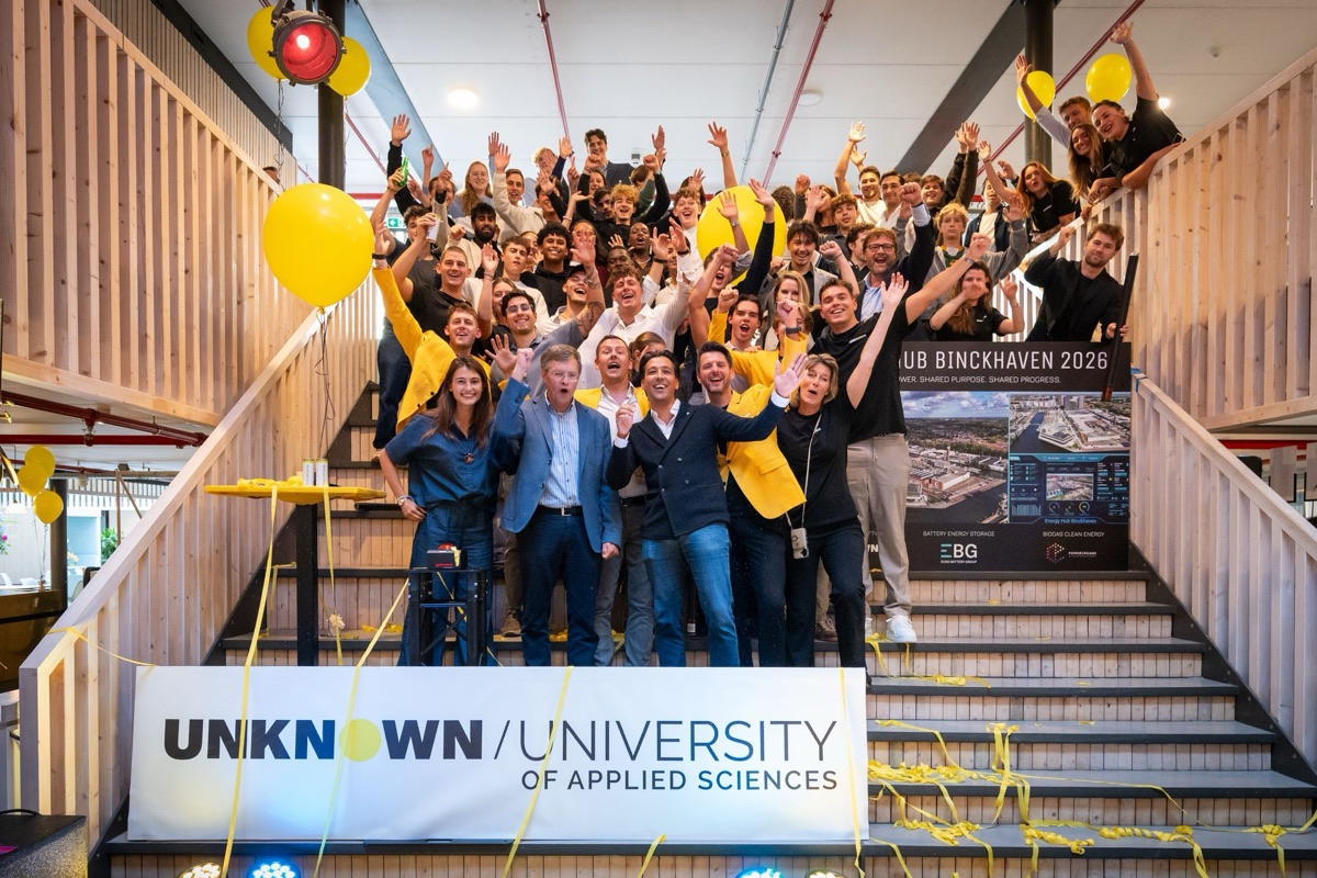 Students and staff cheering on a staircase under yellow balloons